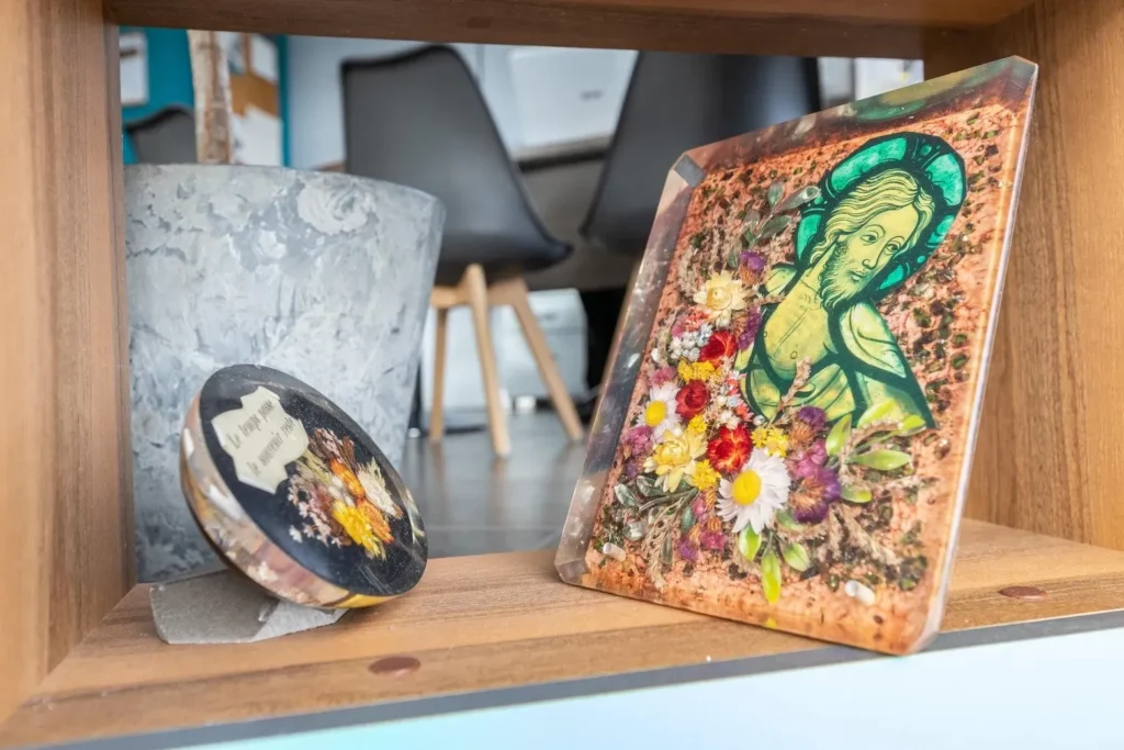 Plaque mortuaire artisanale avec inclusions de fleurs séchées et motif religieux