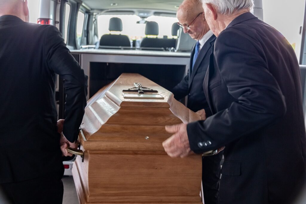 personnels funeraires portant cercueil