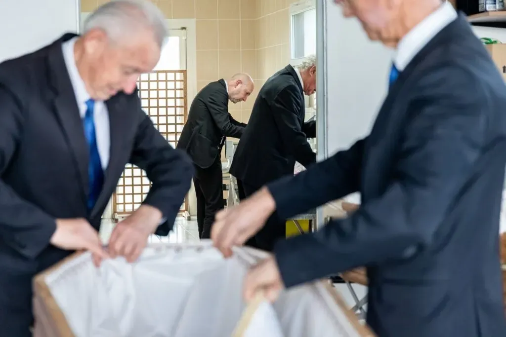 Porteurs funéraires préparant le capiton à l'intérieur d'un cercueil
